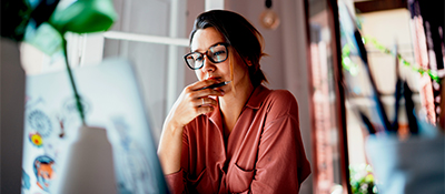 Young businesswoman thinking about something while sitting front open portable laptop computer reading email from client, long hours of work concept